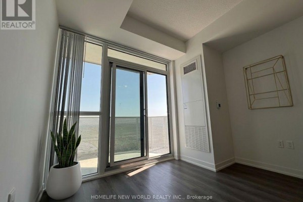 Apartment living space with large sliding glass doors, sheer curtains, and a potted plant. - 3212 - 28 Interchange Way, Vaughan