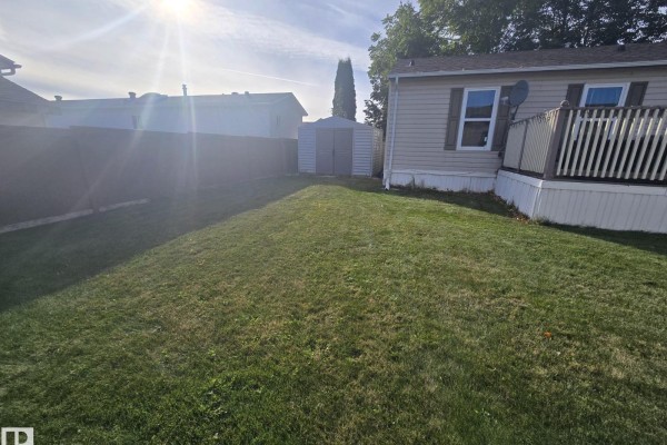 View of a grassy backyard with a storage shed and a mobile home. - 3213 Lakewood Close Nw Nw, Edmonton