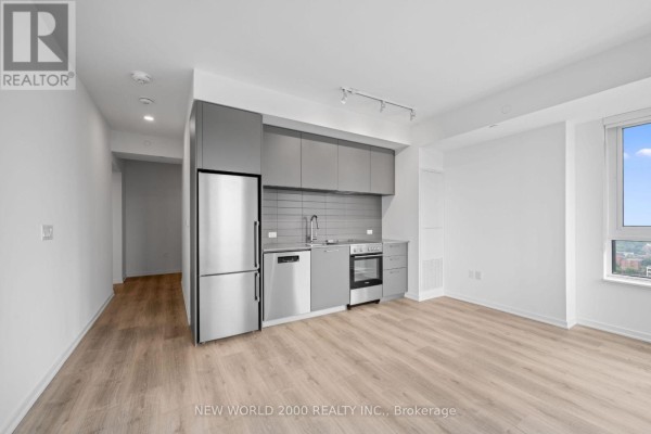 Modern grey kitchen with stainless steel appliances and light wood floors. - 3214 - 101 Roehampton Avenue, Toronto