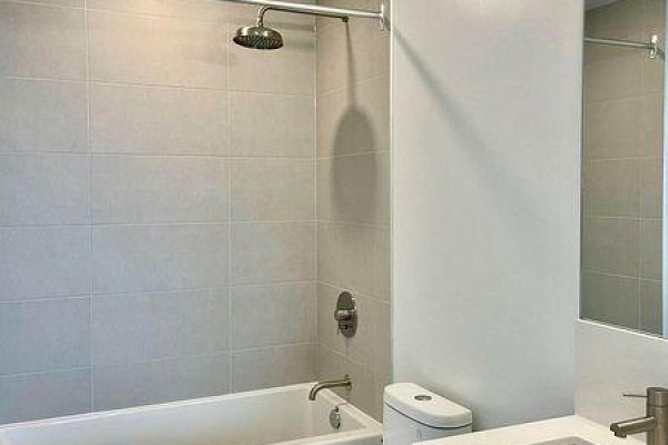 Close-up of bathtub, shower, toilet, and vanity in bathroom. - 3215 - 55 Mercer Street, Toronto