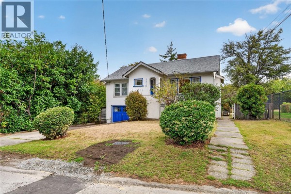 Front view of the house with a concrete driveway and sidewalk leading to the entrance. - 3219 Rutledge St, Saanich