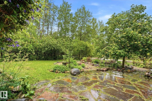 Spacious wooden deck with sectional seating, chairs, tables, and a barbecue grill. - #322 57230 Range Road 25, Rural Barrhead County