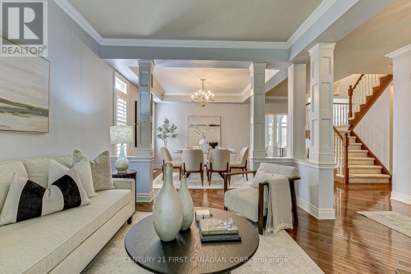 Living room and dining room area with hardwood floors, columns, and a chandelier. - 322 Chambers Place, London North