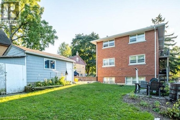 Spacious backyard with patio furniture, grass area, and trees - 322 Edwin Street Unit# 1, Kitchener