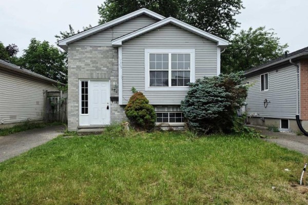 Front exterior of a residential house with a grey roof, siding, and brick accents. - 322 Fleming Drive, London East