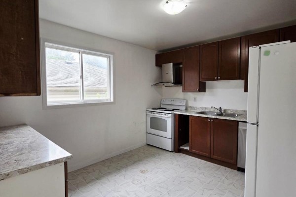 Kitchen with dark brown cabinetry, white appliances including a stove and refrigerator, and a granite-look countertop. - 322 Fleming Drive, London East