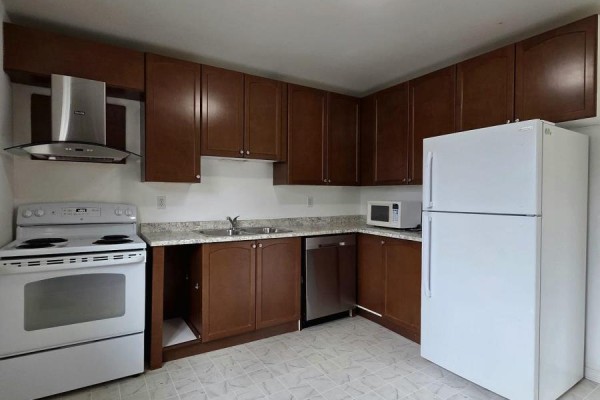 Kitchen with dark brown cabinets, white stove, dishwasher, stainless steel range hood, and a white refrigerator. - 322 Fleming Drive, London East