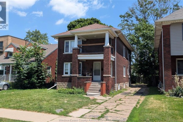 Front exterior of a brick duplex with a paved driveway. - 322 Partington Unit# Upper, Windsor