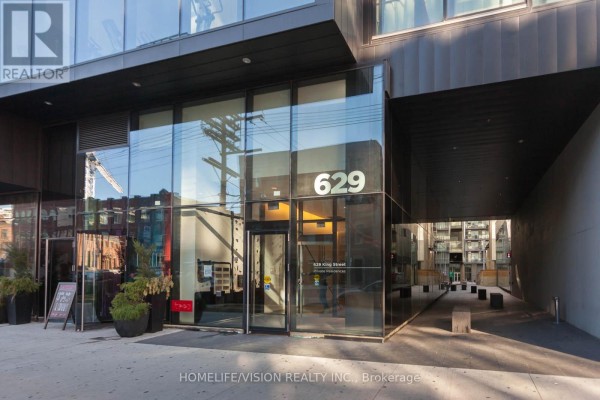 Glass entrance doors and lobby of 629 King Street West building with signage. - 323 - 629 King Street W, Toronto