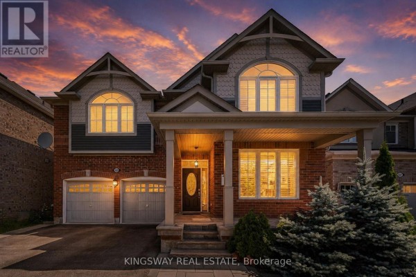 Modern house under construction with a dark siding and light stone facade and a double garage. - 323 Cochrane Terrace, Milton