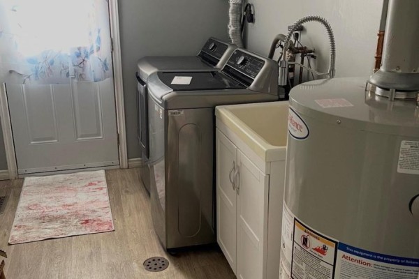 Washer, dryer, utility sink, and water heater in laundry room - 323a Wentworth Crescent Thunder Bay