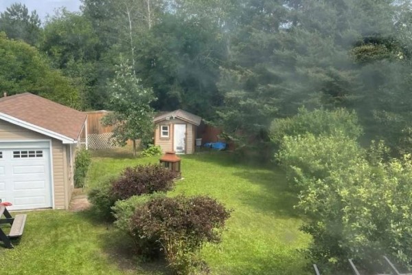 Backyard with garage, shed, deck, lawn, and trees - 323a Wentworth Crescent Thunder Bay