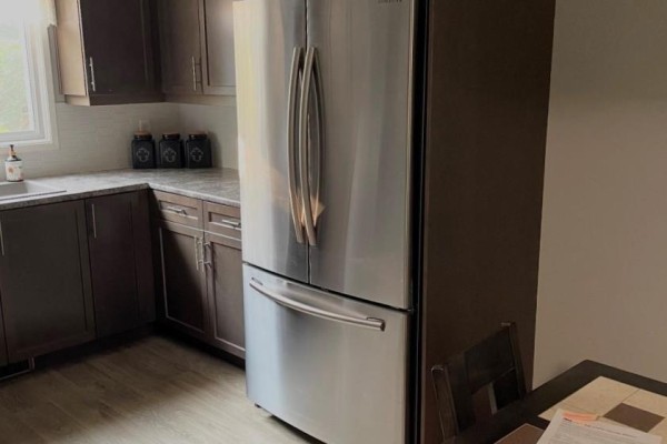 Kitchen with dark brown cabinets, a stainless steel refrigerator, and granite countertops. - 323a Wentworth Crescent, Thunder Bay