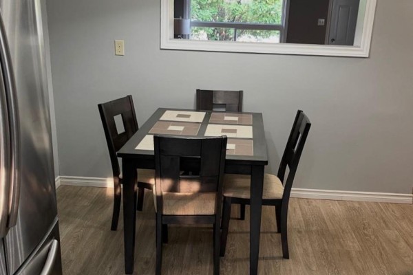 Dining area with table, chairs, chandelier, mirror, and fridge - 323a Wentworth Crescent Thunder Bay