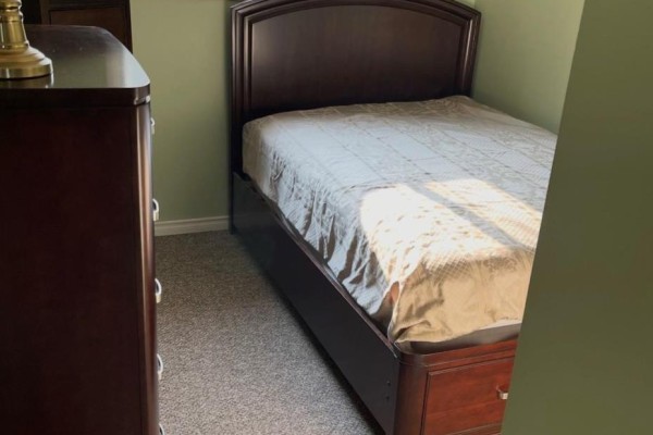 Bedroom with a single bed and dark wood dresser - 323a Wentworth Crescent Thunder Bay