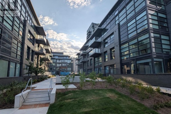 Landscaped courtyard with greenery and walkways between buildings. - 323c - 1612 Charles Street, Whitby