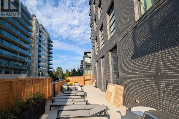 Outdoor terrace with lounge chairs and wooden fencing beside the building. - 323c - 1612 Charles Street, Whitby