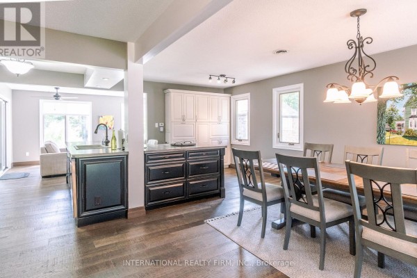 Formal dining room with large window, wood table set for ten, and artwork. - 324 Bethune Drive N, Gravenhurst)