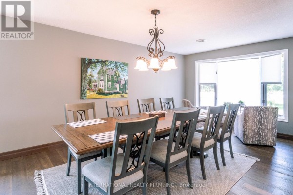 View of the entryway from the dining room, showing the front door and staircase. - 324 Bethune Drive N, Gravenhurst)