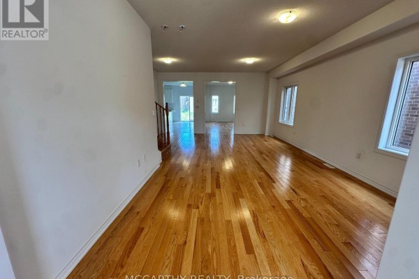Open concept living and dining area with polished hardwood floors and white walls. - 324 Moody Street, Southgate