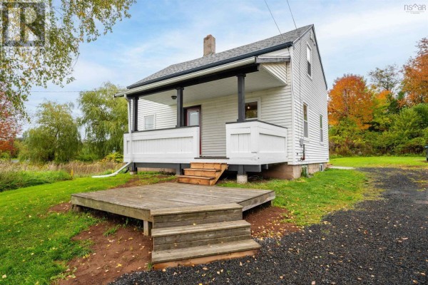 View of the white clapboard house from the driveway, showing trees and a grassy yard. - 324 Wentworth Road, Windsor