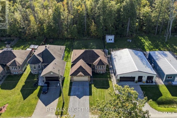 Overhead view of houses on a street, with the main house centered, flanked by a large garage and another home. - 3240 Goldstein Road, Severn