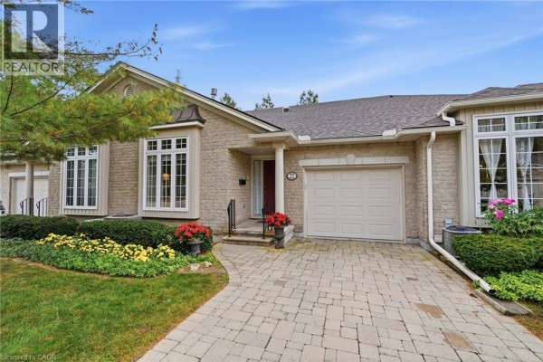 A wooden deck with patio furniture and planters, overlooking a treed backyard. - 3241 Montrose Road Unit# 22, Niagara Falls