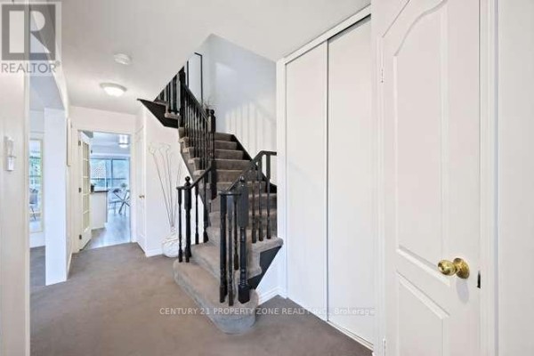 Hallway with carpeted stairs and black railings - 3242 Tortola Court Mississauga