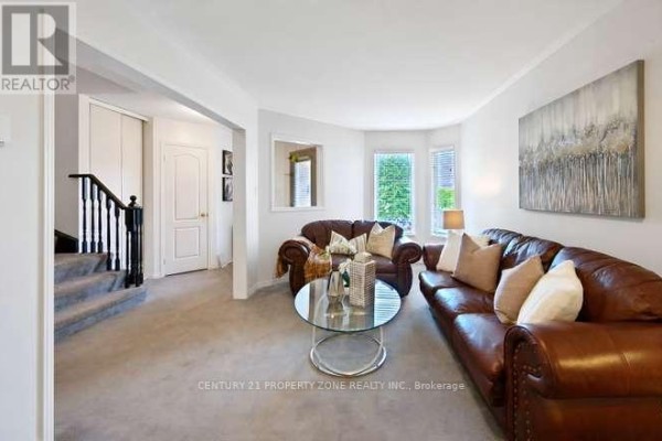 Leather sofas and glass coffee table in living room with bay windows - 3242 Tortola Court Mississauga