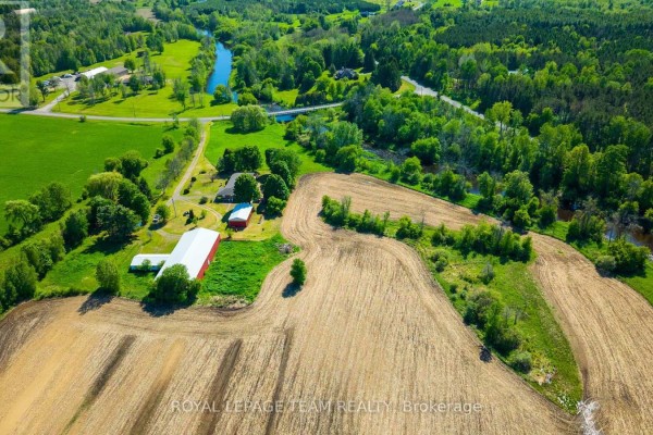 Expansive aerial view of farmland, river, and wooded areas. - 3245 Wallace Road, North Dundas