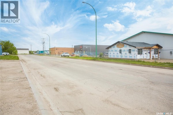 Interior view of an empty room with gray walls, wood-look flooring, and bright ceiling lights. - 325 17th Street W, Prince Albert