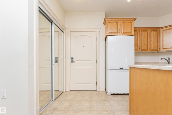 Laundry room with white Samsung front-load washer and dryer, and a wall-mounted electrical panel. - #325 9820 165 St Nw, Edmonton