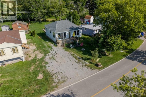 Exterior of 325 Blue Water Parkway, a light blue cottage with a wooden deck and gravel driveway. - 325 Blue Water Parkway, Selkirk