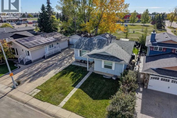 Aerial view of the bungalow with adjacent properties and a park in the background. - 325 Flett Drive Ne, Airdrie