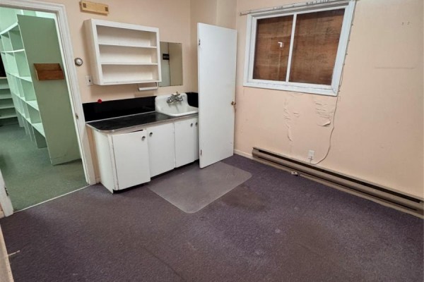 Room with a sink, white cabinets, shelves, a doorway to another room, and a window with covered panes. - 325 Hamilton Avenue, St  John S