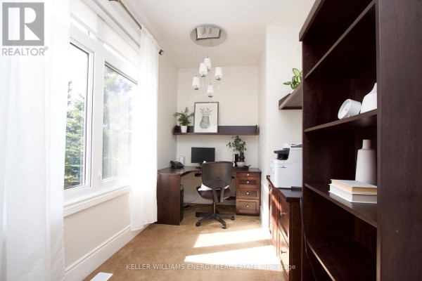 Home office with large window, dark wood desk, chair, and bookshelf. - 325 Zion Line, Cavan Monaghan