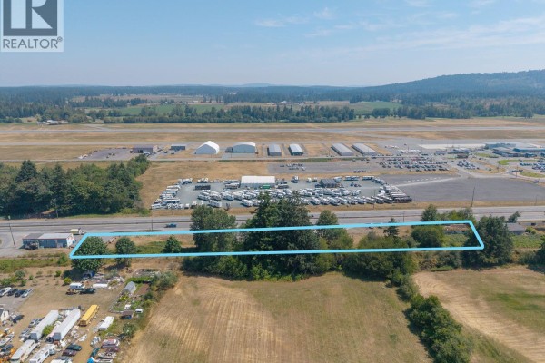 Aerial view of the property lot outlined in blue with Trans Canada Highway and RV dealership on the right. - 3251 Trans Canada Hwy, Nanaimo