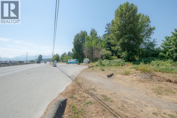 Concrete pad with circular metal covers, concrete barriers, and surrounding vegetation under a blue sky. - 3251 Trans Canada Hwy, Nanaimo