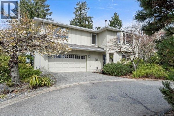 Back deck with white railing and outdoor furniture overlooking a wooded backyard. - 3255 Folkestone Dr, Nanaimo