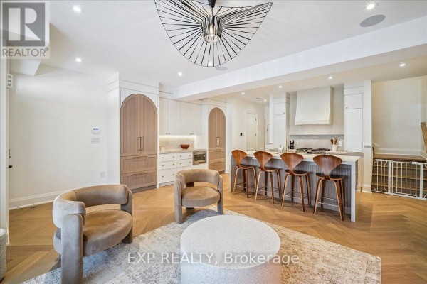 Spacious living area featuring a modern fireplace, art piece, and bar seating - 3266 Sixth Line, Oakville