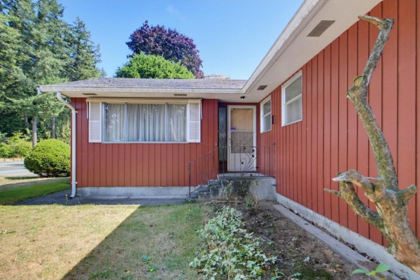 Front entrance of red sided house with small steps and a metal railing. - 32712 Bevan Avenue, Abbotsford