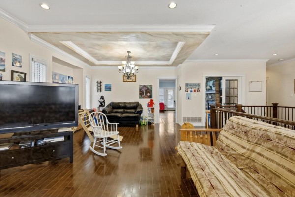 Living room with hardwood floors, coffered ceiling, and large TV - 32758 Lightbody Street, Mission