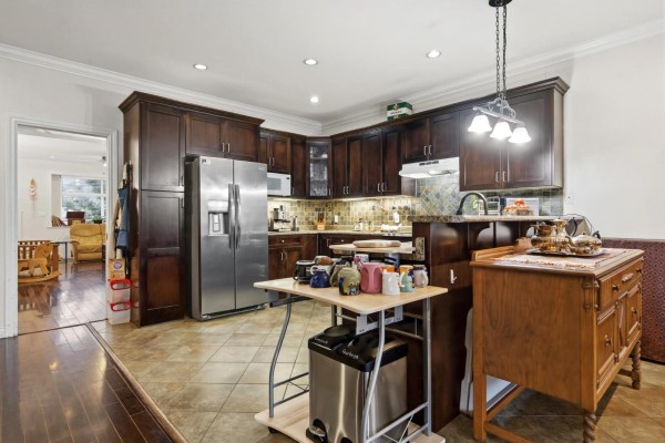Kitchen with dark wood cabinets, stainless steel appliances, and tile flooring - 32758 Lightbody Street, Mission