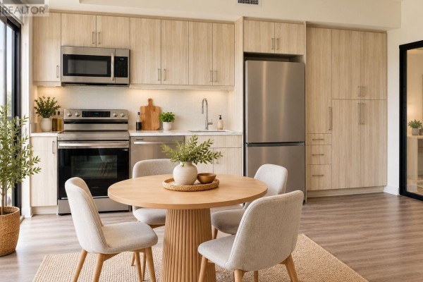 Kitchen area with light wood cabinets, stainless steel appliances, and a round dining table. - 328 - 350 Prince Charles Drive S, Welland