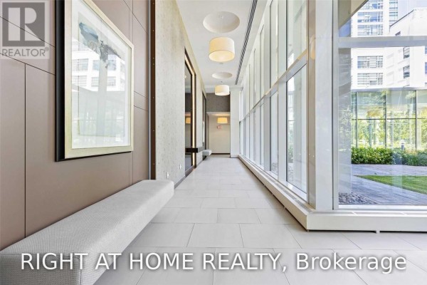 Interior hallway with tiled floor, large windows, and grey benches. - 328 - 90 Stadium Road, Toronto