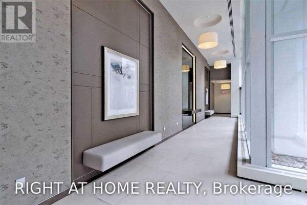 Hallway with modern textured walls, art, and grey bench seating. - 328 - 90 Stadium Road, Toronto