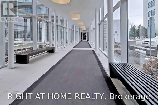 Long indoor walkway with large windows, benches, and carpeted runner. - 328 - 90 Stadium Road, Toronto