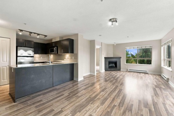 Stainless steel appliances and dark cabinetry in a U-shaped kitchen with granite countertops. - 328 8915 202 Street, Langley