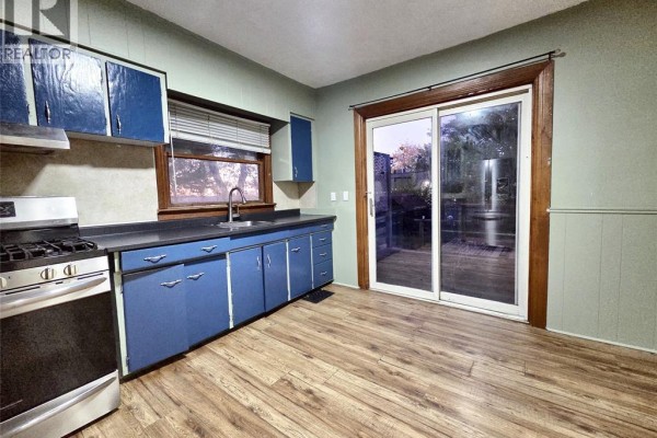 Bedroom with light blue walls, wood laminate flooring, and a white door. - 328 John B Avenue, Windsor