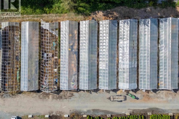 Top-down view of a row of clear-roofed greenhouses with metal framing visible. - 3280 No. 6 Road, Richmond